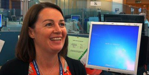 An NHS 24 staff member sitting in front of a computer